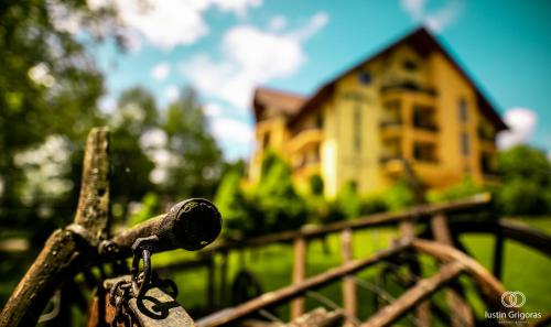 a chain attached to a fence with a house in the background at Pension Vanatorul in Vatra Dornei