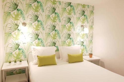 1 dormitorio con cama blanca y papel pintado tropical en InLoveApartments - Typical Alfama Balcony, en Lisboa