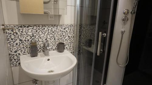 bagno con lavandino e doccia di LEA Apartments a Liepāja