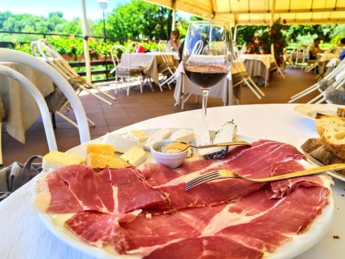a plate of ham and cheese and a glass of wine at L'Oliveto in Cineto Romano