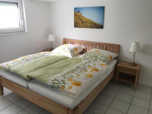 a bed with a blanket and two pillows on it at Ferienhaus Moselglück - kostenlose ÖPNV-Nutzung inbegriffen in Bernkastel-Kues