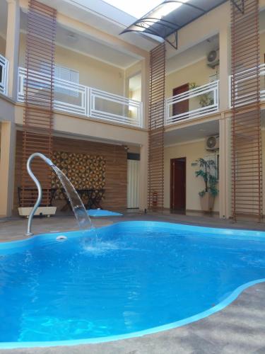 a large swimming pool with a water fountain at Casagrande Olímpia Hotel in Olímpia