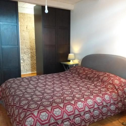 オルヴィエートにあるCharming Apartmentのベッドルーム1室(赤い掛け布団付きのベッド1台付)
