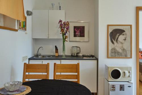 a kitchen with a table and a counter with a vase of flowers at Villa In Bio Garden - You Will Save Money Here in Prague