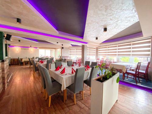 a dining room with tables and chairs and purple lighting at Motel Tiron in Kakanj