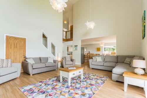 a living room with two couches and a rug at Blackdown Views - New 6 Bedroom Eco House in Dunkeswell