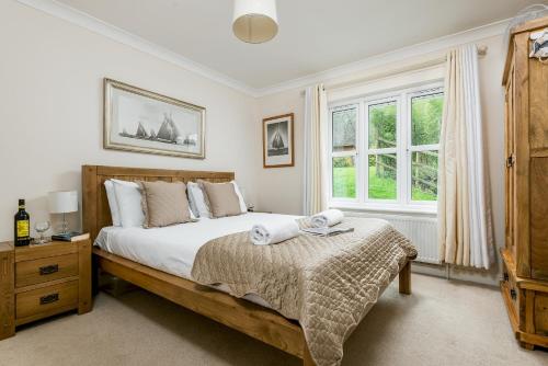 a bedroom with a large bed and a window at Mews Hill, 5 bedroom New Forest Holiday Cottage in Fordingbridge