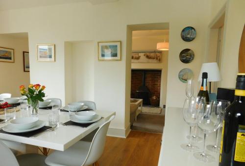 uma sala de jantar com uma mesa branca e copos de vinho em Quay Corner, 5 bed house, Christchurch Dorset em Christchurch