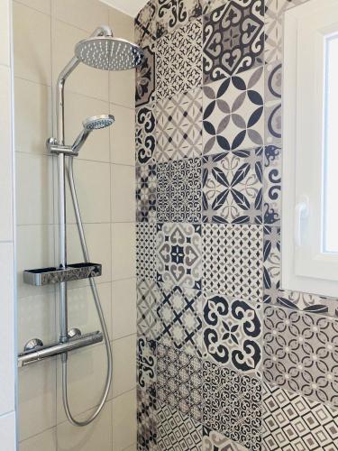 La salle de bains est pourvue d'une douche et d'un mur en carrelage. dans l'établissement L'annexe, à La Cotinière