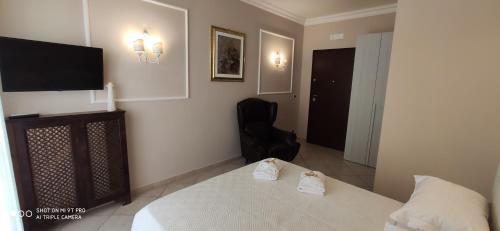 a bedroom with a bed and a flat screen tv at GIOIArooms in Trani