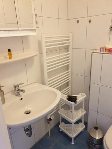 a white bathroom with a sink and a toilet at Altstadtperle in Emden