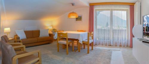 a living room with a table and a couch at Landhaus Haid in Seefeld in Tirol