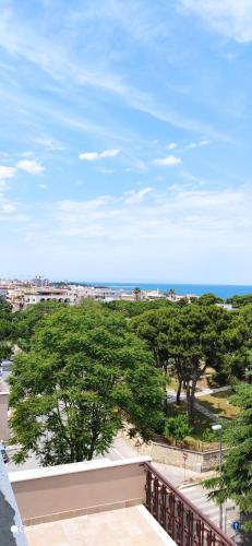 a balcony with trees and the ocean in the background at GIOIArooms in Trani
