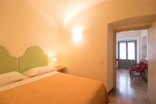 1 dormitorio con 1 cama y 1 silla en una habitación en B&B Entro Le Mura, en Bérgamo