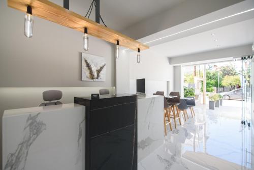 a kitchen with a black and white counter and chairs at Vicky Rooms in Paralia Dionysiou