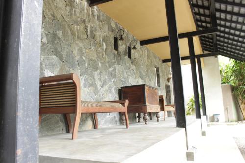 a bench sitting in front of a stone wall at Handagedara Resort & Spa in Mirissa