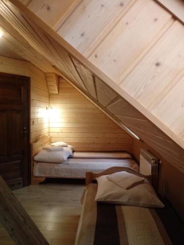 a room with two beds in a wooden cabin at Dom Gościnny BIERWIONO in Cisna