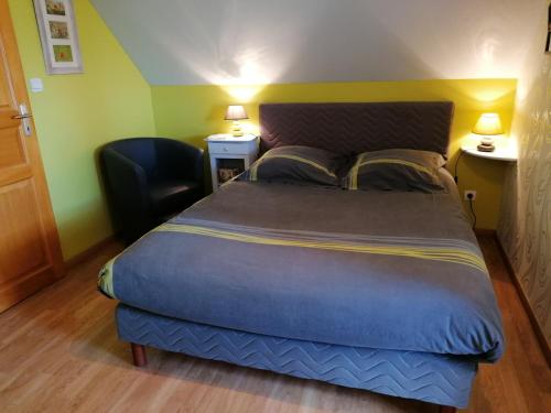 a bedroom with a large bed with two chairs and two lamps at Chambre D'hotes Le Clos Fleuri in Criel-sur-Mer