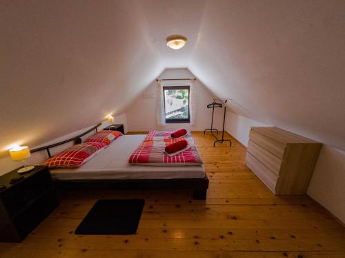 a bedroom with a bed with red pillows on it at Holiday house Tinca in Most na Soči