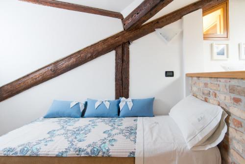 ヴェネツィアにあるWellVenice Campielloのベッドルーム1室(青と白の枕が備わるベッド1台付)