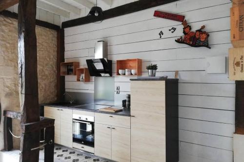 cocina con paredes de madera blanca y fogones en gite Pedelucq en Pouillon