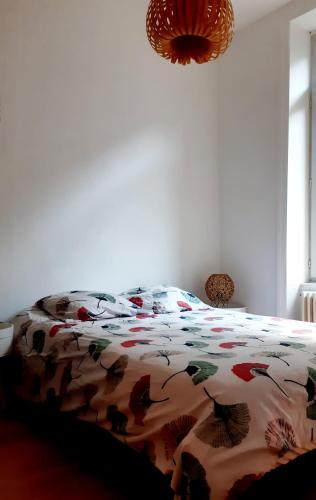 - un lit avec une couette colorée dans une chambre dans l'établissement La Villa des Thermes, à Le Mont-Dore