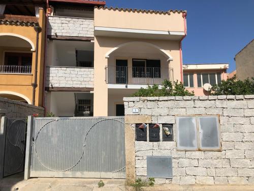 a fence in front of a house with a building at Casa Ale Villasimius in Villasimius