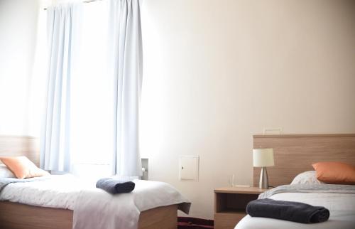 a bedroom with two beds and a large window at Stara Cynkownia in Czechowice-Dziedzice