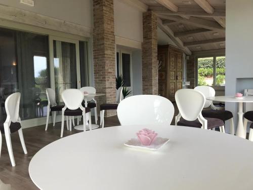 a white dining room with white chairs and a table at Agriturismo Fattoria di Monticello in San Venanzo