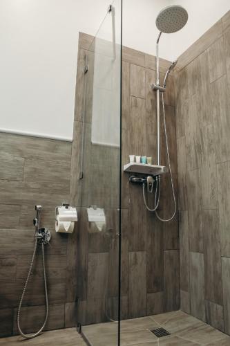 a shower with a glass door in a bathroom at 7 Boutique Hotel in Ustʼ-Kamenogorsk