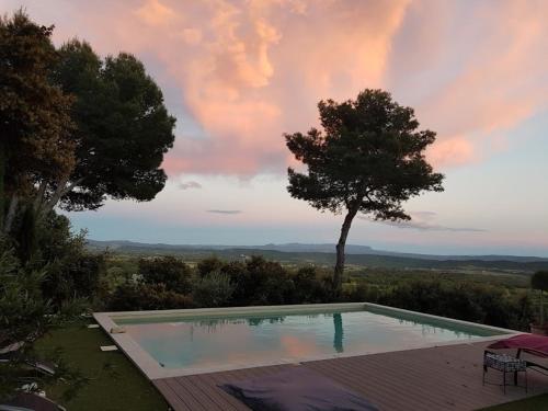 a swimming pool on top of a house with a tree at La Maison de Charlie in Vaugines