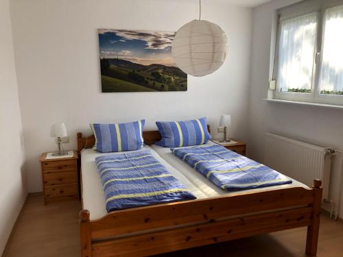 Schlafzimmer mit einem Bett mit blauen und weißen Kissen in der Unterkunft Ferienhaus Irene in Vogtsburg