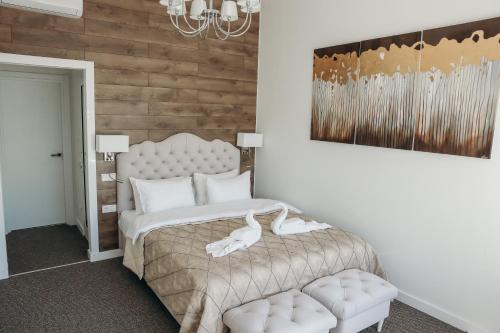 a bedroom with a white bed and a chair at 7 Boutique Hotel in Ustʼ-Kamenogorsk