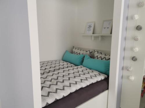 a small bedroom with a bed with blue pillows at City-Apartment Perle in Bremerhaven