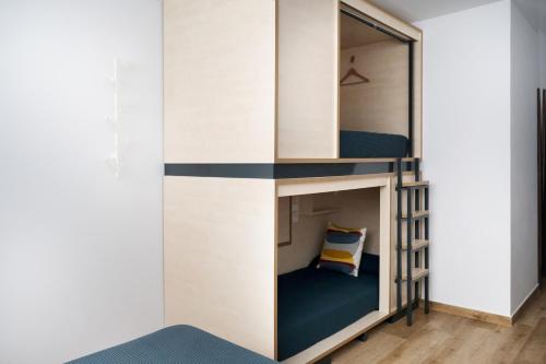 a room with a bunk bed with a mirror at TAKE SURF Hostel Conil in Conil de la Frontera