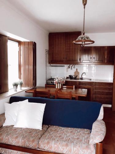 ein Wohnzimmer mit einer blauen Couch in einer Küche in der Unterkunft Casa dos Pinheiros in São Pedro de Muel