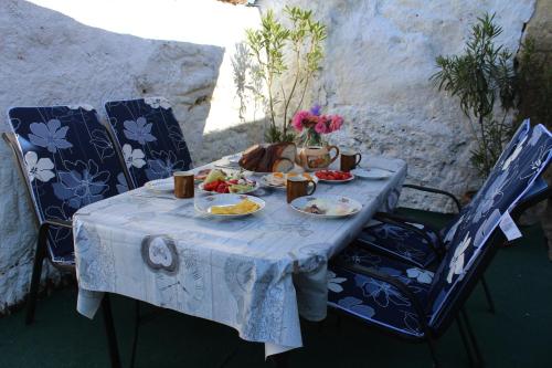 uma mesa com pratos de comida e flores em Kakukkfu Barlang-Vendeghaz em Noszvaj