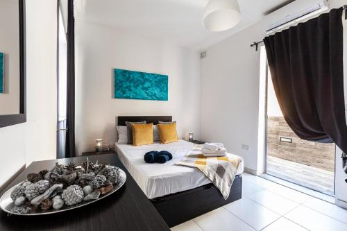 a bedroom with a bed and a tray of food on a table at Z4 - SEAFRONT apartment in St. Paul's Bay