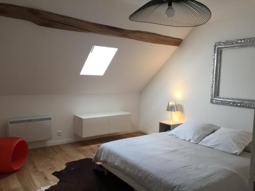 1 dormitorio con cama blanca y ventana en Taboo Treigny, en Treigny