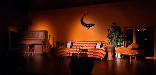 a living room with a couch and a cat on the wall at La Baleine Endiablée Microbrasserie in Rivière-Ouelle