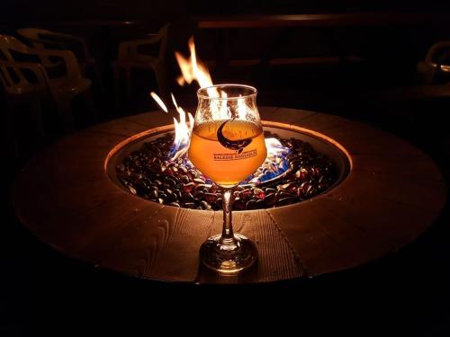 a glass of wine sitting on top of a table at La Baleine Endiablée Microbrasserie in Rivière-Ouelle