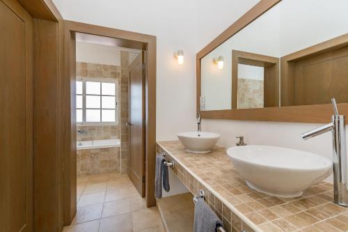 uma casa de banho com 2 lavatórios e um espelho grande em Luxury & Modern Villa with Pool at Cocotal Golf & Country Club em Punta Cana