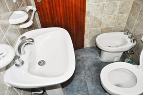 a bathroom with a toilet and a sink at Hotel del Mar in Valeria del Mar
