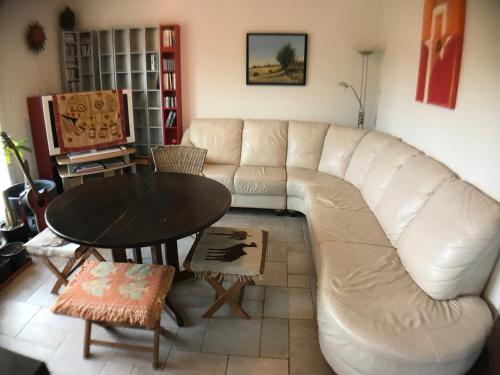 a living room with a white couch and a table at Centre ViaYoga in Saint-Cergue