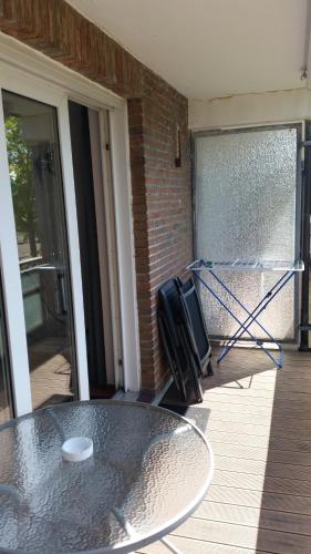 a glass table sitting on a porch with a glass door at Apartment Wiesener in Büsum