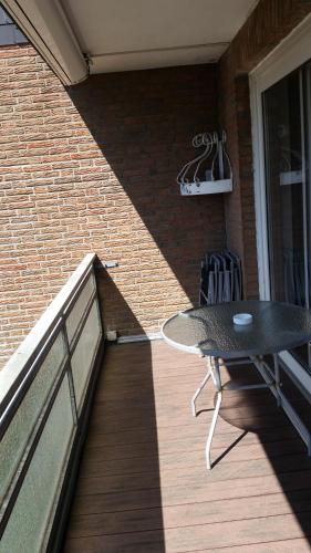 a balcony with a table and a brick wall at Apartment Wiesener in Büsum