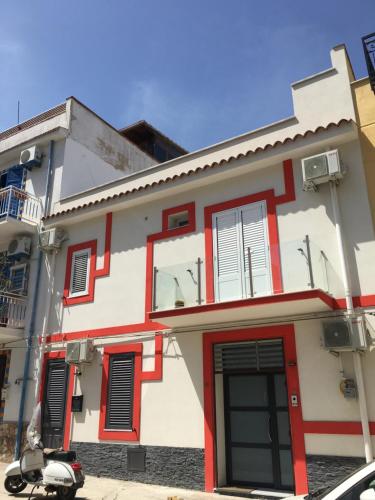 a white and red building with a scooter parked in front at Casa Escape in Terrasini