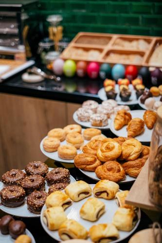 a bunch of different types of donuts on plates at Hotel Cetina Casa de las Telas Sevilla in Seville