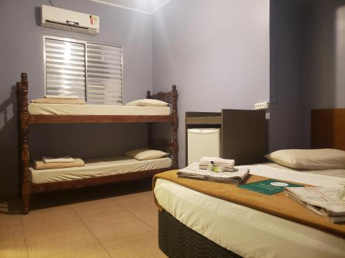 a room with three bunk beds and a window at Pousada Beira Mar in Santos