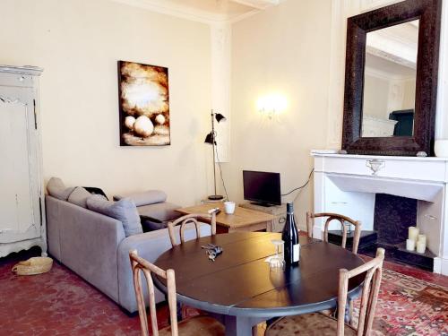 un salon avec une table et un canapé dans l'établissement Ancienne maison de maîtres, à Lourmarin